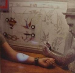 Virtuali tatuiruotė Paspaudus mygtuką šalia pasirinkto paveiksliuko ir ant rankos pradeda atsirasti projekcinė tatuiruotė.