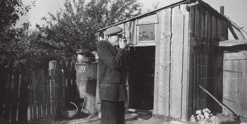 Mokytojas Antanas Preidys fotografuoja Žalpelių kaime bulviakasio talkos metu 1955 m. Romualdo Ozolo nuotrauka keistą ledinį dvelksmą, kuris tik paskutiniais metais šiek bei tiek atsileidžia.