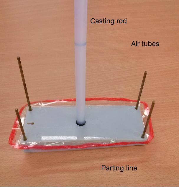 Fig. 3.15 Part with set casting rod, air tubes and parting line 2. Build up silicone mold box.